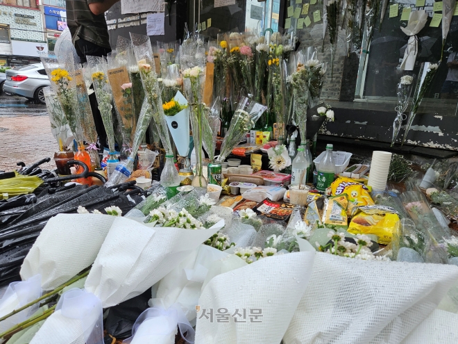 23일 오전 서울 관악구 신림역 인근 상가 골목에 마련된 흉기난동 사건으로 숨진 20대 남성을 추모하는 공간에 국화가 놓여 있다. 강동용 기자