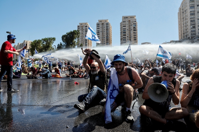사법개혁법 통과로 이스라엘 민주주의가 후퇴할 것을 우려하는 시민들이 의회 앞에서 경찰의 물대포를 맞고 있는 모습. 예루살렘 로이터 연합뉴스