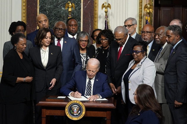 조 바이든 미국 대통령이 25일 백악관에서 카멀라 해리슨 부통령 등이 지켜보는 가운데 흑인 소년 에밋 틸을 기리는 국가 기념물 지정 성명서에 서명하고 있다. 워싱턴DC AP 연합뉴스