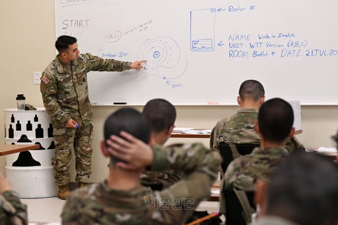 미군 교관이 교실에서 교육생들에게 병기본훈련 교육을 하고 있다.