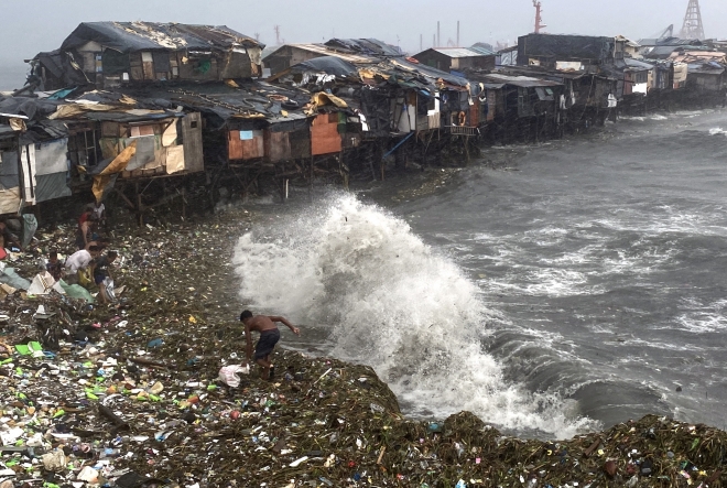 5호 태풍 독수리가 필리핀 북부를 강타한 26일(현지시간) 마닐라만(灣)의 한 마을에서 주민들이 해안에 밀려온 자재를 줍고 있다. 2023.7.26 EPA 연합뉴스