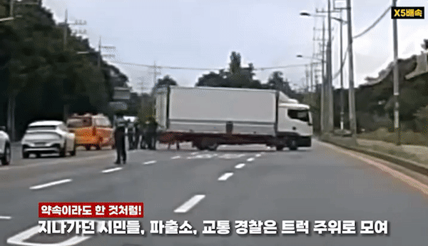 지난달 30일 대전 대덕구의 6차선 도로에서 멈춘 트럭을 경찰관과 시민 등 10여명이 밀고 있다. 대전경찰청 유튜브