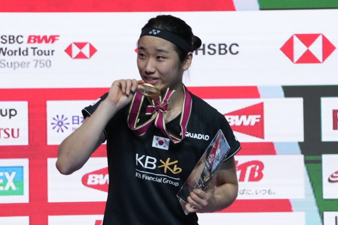 안세영이 30일 일본오픈 여자단식에서 우승한 뒤 올해 7번째로 따낸 금메달을 깨물고 있다.  AP 연합뉴스