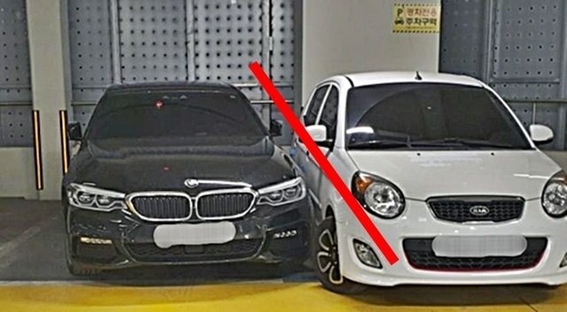 주차선을 넘어온 BMW 차량 옆에 경차가 주차돼 있다. BMW 차주는 차를 못 빼 경찰의 도움을 받았다. 제보자 A씨 제공/연합뉴스