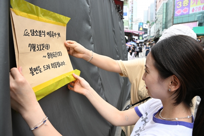 폭염이 계속되는 31일 오후 서울 중구 남대문시장에 한 매장 주인이 여름 휴가를 알리는 안내문이 붙이고 있다. 2023.7.31. 도준석 기자