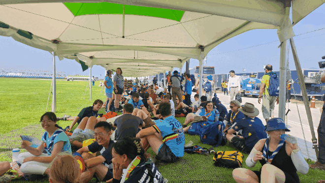 무더운 날씨에 잼버리 대회에 참가한 스카우트 대원들이 그늘로 모여 휴식을 취하고 있다.