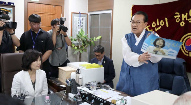 3일 용산 대한노인회 중앙회에서 김호일 회장이 노인폄하 발언 사과를 위해 방문한 더불어민주당 김은경 혁신위원장과 면담 중 위원장의 뺨 대신 사진을 때리고 있다. 연합뉴스