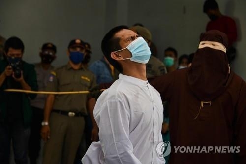 인도네시아 아체주에서 한 남성이 회초리에 맞으며 고통스러워 하고 있다. AFP 연합뉴스 자료사진
