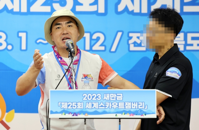 한국스카우트연맹 전북연맹 지도자가 영지 내 성범죄 발생을 주장하며 퇴소 기자회견을 연 가운데  조직위 관계자가 이를 제지하고 있다. 연합뉴스