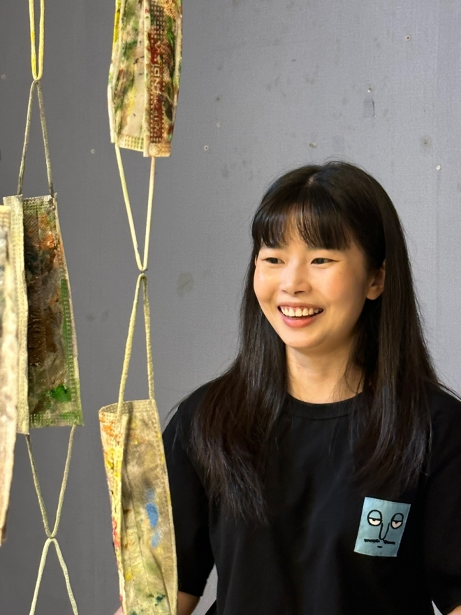 박성희 작가가  자신의 작품 앞에서 활짝 웃고 있다.