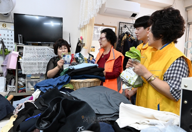 지난 4일 성북구 보문동 통장들이 옷 수선집을 찾아 고립은둔청년 발굴 및 지원 정책을 안내하는 전단지를 건네고 있다. 도준석 기자