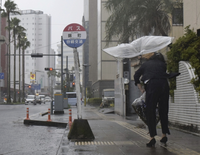 태풍 ‘카눈’에 뒤집힌 우산 붙잡는 日 규슈 시민