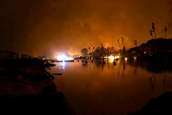미국 하와이주에 9일(현지시간) 발생한 대형 산불로 인명과 재산 피해가 늘고 있는 가운데 카훌루이섬의 라하이나 역사 마을 대부분이 거친 불길에 휩싸여 있다. 주민 제공 로이터 연합뉴스