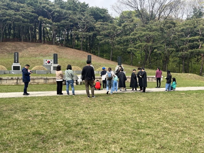 서울 용산구가 운영하는 21세기 한인애국단 참가자들이 삼의사 묘역 앞에서 체험활동을 하고 있다. 용산구 제공