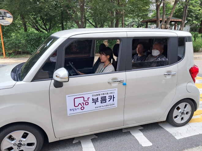 성남시독거노인종합지원센터는 거동이 불편한  어르신이 병원 진료나 공공기관 방문이 필요할 때 차량과 동행 도우미를 지원하는‘부름카 서비스’를 시범 도입했다. 도우미가 어르신을  보건소로 모시고 가는 모습.    성남시 제공