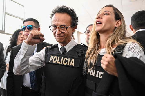 총격으로 암살된 에콰도르 대선 후보를 대신해 대권에 도전하게 된 크리스티안 수리타(가운데) 후보가 13일(현지시간) 수도 키토에서 방탄조끼 차림으로 결의를 다지고 있다. 오른쪽은 부통령 후보 안드레아 곤살레스. 키토 AFP 연합뉴스