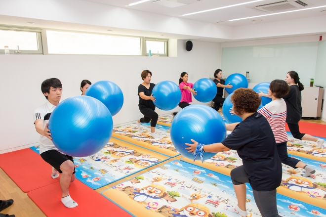 양천구 보건지소에서 구민들이 건강운동 관리사의 도움을 받아 짐볼로 균형을 잡는 연습을 하고 있다. 2023.8.14  양천구 제공