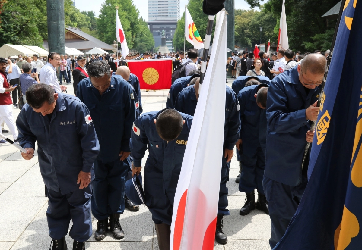 태평양전쟁 A급 전범이 합사된 도쿄 지요다구 야스쿠니신사에서 일장기와 ‘구국’(救國) 깃발을 든 사람들이 신사를 향해 절하고 있는 모습.  도쿄 연합뉴스