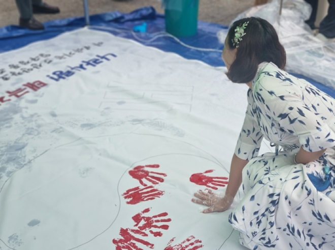 지난 12일 압구정 도산공원에서 열린 ‘나라사랑 손도장 태극기 행사’에 참석한 이새날 의원이 손도장을 찍고 있다.