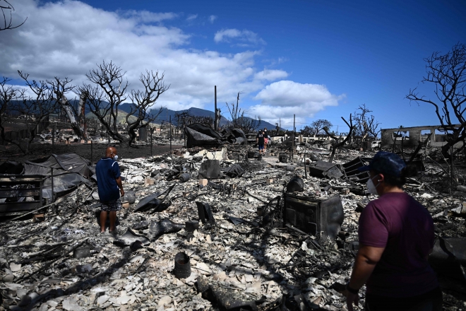 미국 하와이주 마우이섬 라하이나 주민들이 11일(현지시간) 대형 산불로 잿더미가 된 집을 살피고 있다.  2023.08.13 AFP=연합뉴스