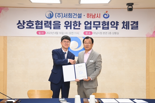 이현재(오른쪽) 하남시장과 김원철(왼쪽) 서희건설 대표가 16일 본사 이전에 따른 상호협력을 위한 업무협약을 체결하고 기념사진을 찍고 있다.   하남시 제공