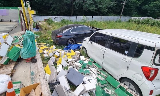 15일 경기도 부천의 한 주유소로 돌진한 BMW 차량이 담벼락을 뚫고 공터로 추락했다. 사진 경기 부천소방서 제공
