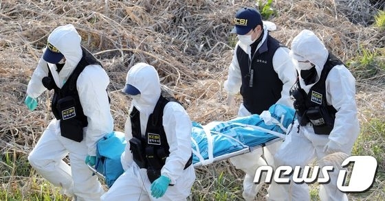 경찰이 2020년 봄 최신종에 의해 희생된 여성의 시신을 옮기고 있다.