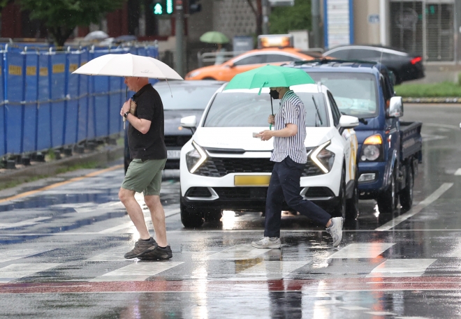 23일 오후 서울 중구 서울광장 인근에서 시민들이 우산을 쓰고 이동하고 있다. 2023.8.23 연합뉴스
