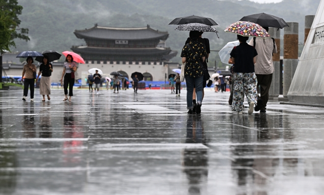 더위가 가고, 아침저녁으로 시원한 바람이 분다는 절기 ‘처서’(處暑)인 23일 서울 광화문광장에서 시민들이 우산을 쓰고 지나가고 있다. 2023.8.23 오장환 기자