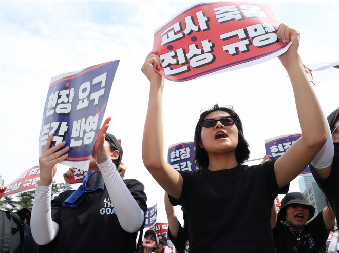 지난 26일 오후 서울 영등포구 국회 앞에서 전국교사일동이 연 ‘국회 입법 촉구 추모집회’에서 참가자들이 손팻말을 들고 있다. 연합뉴스