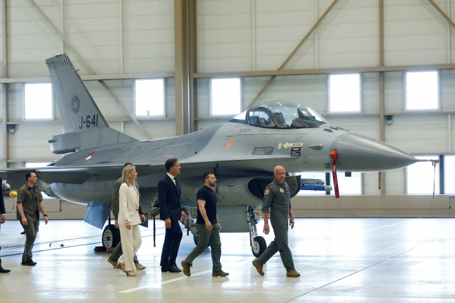 20일(현지시간) 깜짝 순방에 나선 볼로디미르 젤렌스키 우크라이나 대통령이 네덜란드 아인트호벤에서 마르크 뤼터 네덜란드 총리와 F-16 전투기 앞을 지나고 있다. 2023.8.20 로이터 연합뉴스