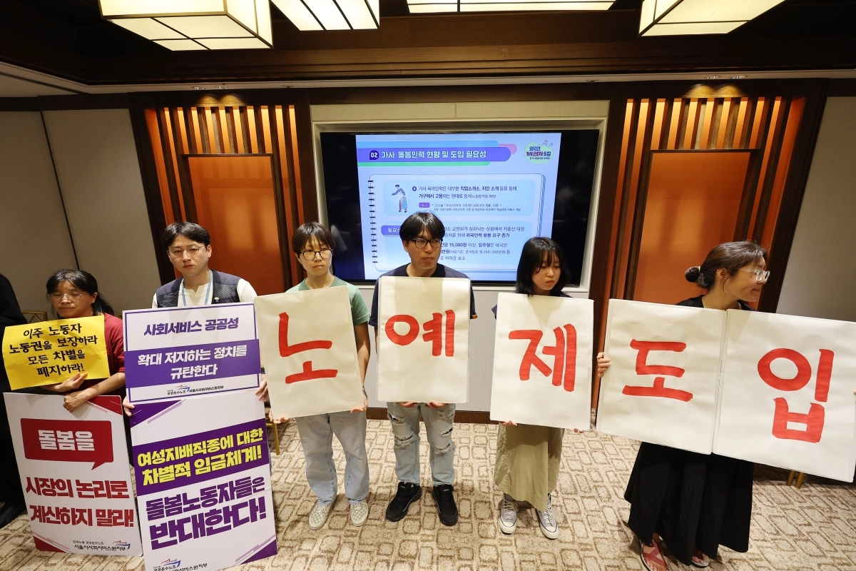 지난 7월 31일 오전 로얄호텔서울에서 열린 외국인 가사근로자 도입 시범사업 관련 공청회에서 공청회를 규탄하는 개인과 단체 관계자들이 손팻말을 들고 있다. 2023.7.31 연합뉴스