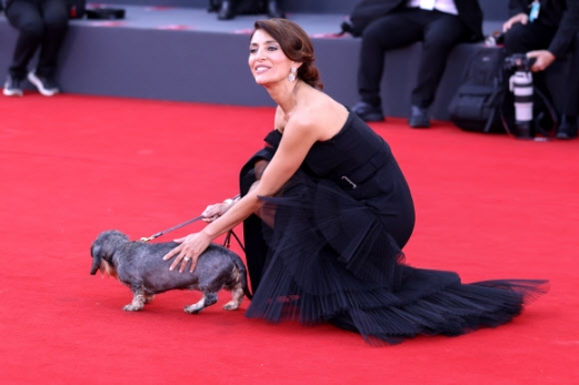 Caterina Murino poses for photographers with a dog upon arrival for the premiere of the film ‘Poor Things’ during the 80th edition of the Venice Film Festival in Venice, Italy, on Friday, Sept. 1, 2023. AP