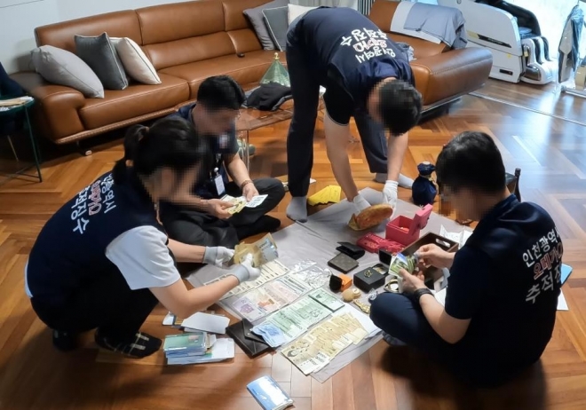 인천시 ‘오메가 추적 징수반’이 고액체납자의 자택에서 현금과 귀금속 등을 압류하고 있다.[인천시 제공]