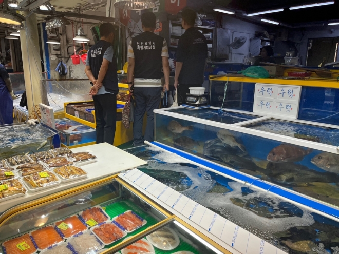 인천 특별사법경찰이 한 어시장 내 수산물 판매업소에서 원산지 표시 위반 여부를 확인하고 있다.[인천시 제공]