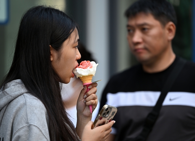 늦더위가 기승을 부리는 6일 서울 중구 명동 거리에서 외국인 관광객이 아이스크림을 먹으며 더위를 피하고 있다. 2023.9.6 오장환 기자