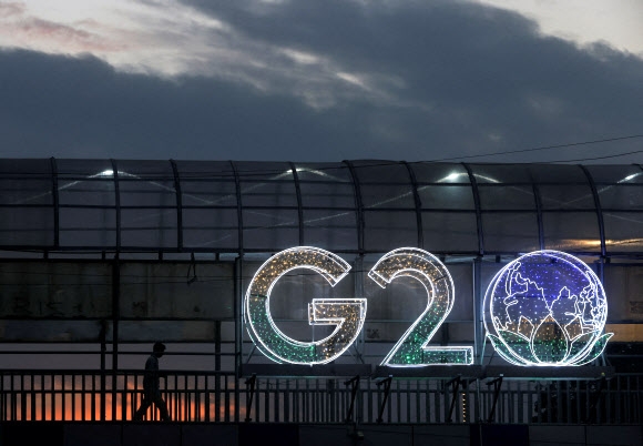 인도 수도 뉴델리의 한 남성이 6일(현지시간) 스카이워크에 설치된 주요 20개국(G20) 정상회의 상징물 쪽으로 걸어가고 있다. 뉴델리 로이터 연합뉴스