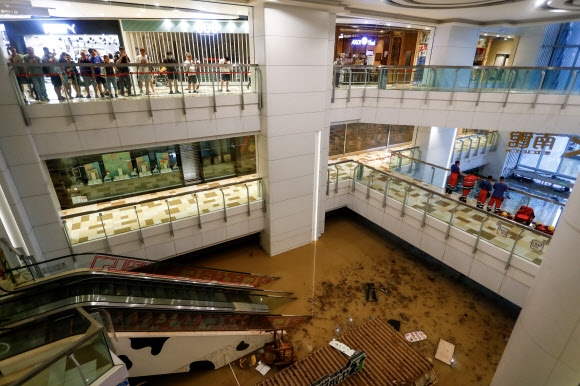 중국 홍콩 주민들과 소방관들이 8일 기록적인 폭우에 잠긴 쇼핑몰 안을 바라만 보고 있다. 홍콩 EPA 연합뉴스