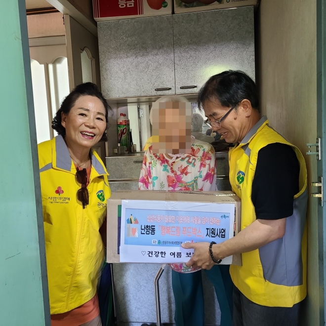 서울 관악구 관계자들이 홀로 거주하는 어르신(가운데)에게 음식을 전달하고 있다. 관악구 제공