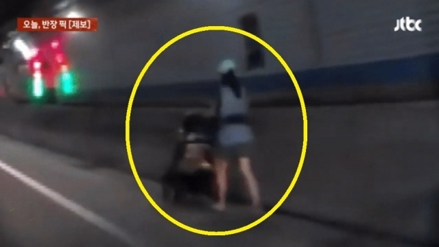 차들이 빠르게 달리는 터널 안에서 한 여성이 갓길을 따라 유모차를 끌며 걸어가는 모습이 포착돼 논란이다. JTBC 캡처