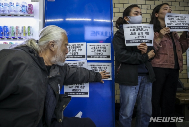 박경석 전국장애인차별철폐연대 상임공동대표가 8일 오전 서울 중구 을지로3가역에서 열린 장애인 권리스티커 부착, 서울교통공사 강제억류 인권위원회 진정 기자회견에서 승강장에 스티커를 붙이고 있다.