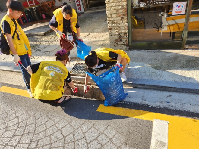 서울 금천구 자원봉사에 나선 주민들이 지난 9일 서울 금천구청 일대에서 허리를 숙여가며 빗물받이를 깨끗이 청소하고 있다. 2023.9.12  금천구 제공