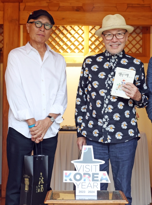 전 세계 10여개국에서 번역·출간된 ‘고독한 미식가’ 원작자 구스미 마사유키(오른쪽) 작가가 허영만(왼쪽) 작가의 책에 사인을 받은 뒤 함께 포즈를 취하고 있다. 문화체육관광부 제공