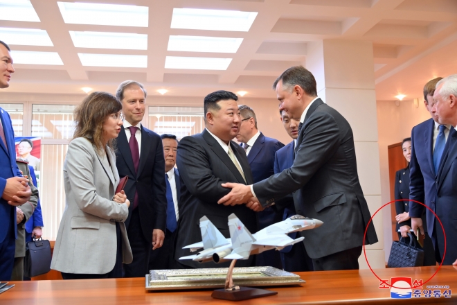 김정은 북한 국무위원장이 지난 15일 러시아 하바롭스크주 콤소몰스크나아무레시의 유리 가가린 전투기 공장을 방문했다고 조선중앙통신이 16일 보도했다. 김 위원장의 여동생 김여정 노동당 부부장이 러시아 비행기 공장 방문 당시 들었던 가방(붉은 원)이 프랑스 고가·사치품 브랜드 ‘크리스찬 디올(Christian Dior SE)’의 제품으로 추정된다.   조선중앙통신 연합뉴스