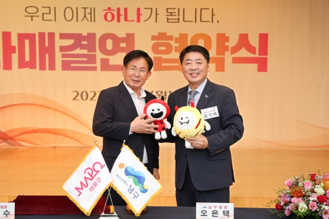 박강수(왼쪽) 서울 마포구청장과 오은택 부산 남구청장이 지난 18일 부산 남구청에서 열린 자매결연 협약식에서 홍대 레드로드 캐릭터 인형을 들고 기념 촬영을 하고 있다. 2023.9.20 마포구 제공