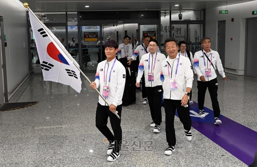 태극기를 앞세운 대한민국 선수단 본진이 20일 중국 항저우 샤오산 국제공항을 통해 입국하고 있다. 항저우 오장환 기자