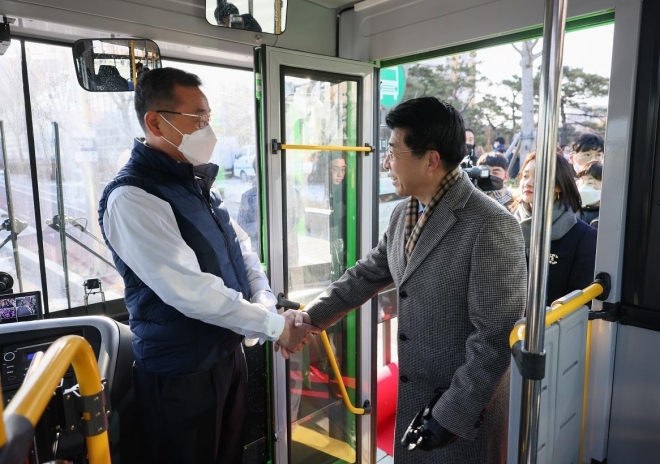 지난해 마을버스 개통 당시 서강석(오른쪽) 송파구청장이 버스기사를 격려하며 악수를 하고 있다. 송파구 제공