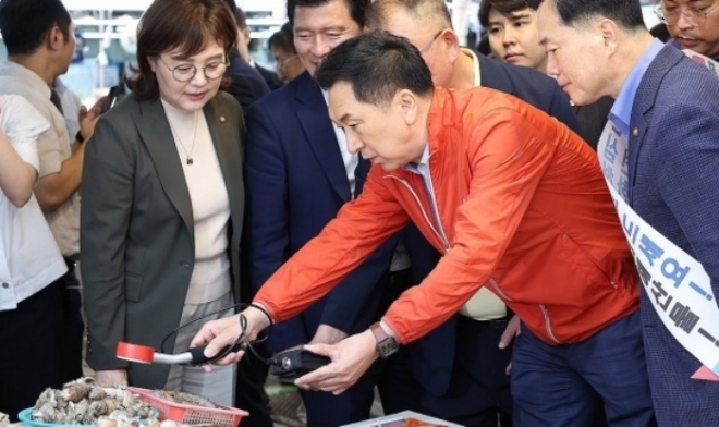 국민의힘 김기현 대표가 22일 대구 북구 매천동 수산물시장을 찾아 수산물 방사능 측정을 해보고 있다. 연합뉴스