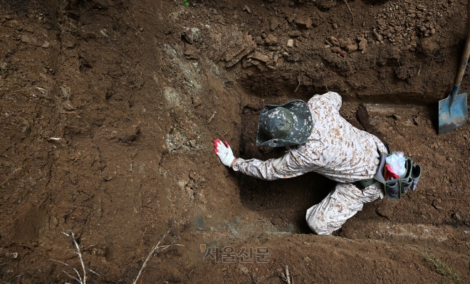 장묘업자 김왕기(62)씨가 지난달 27일 강원 춘천의 한 야산에서 유골을 수습하고 있다. 오장환 기자