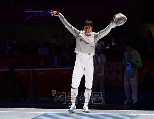 오상욱이 25일 중국 항저우 전자대학에서 열린 펜싱 사브르 결승에서 구본길을 꺾고 우승한 뒤 손을 들고 기뻐하고 있다. 항저우 오장환 기자